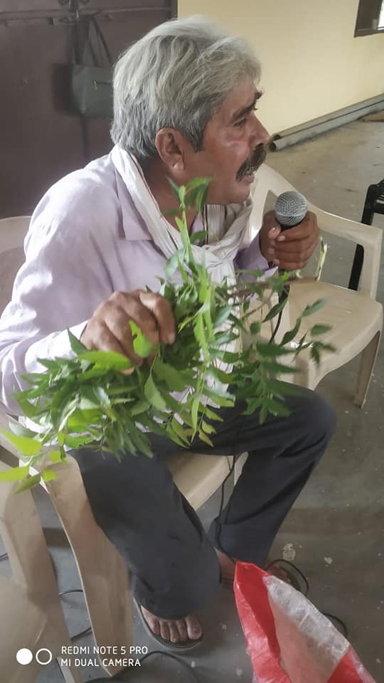 kisan dharambir kamboj showing neem twig for making herbal soap